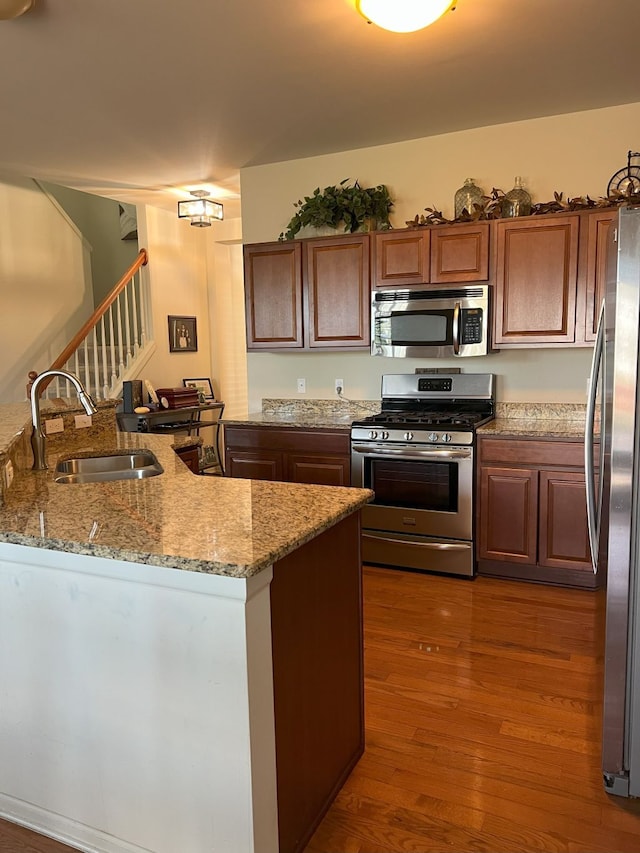 1082 Paddock Dr Unit 78, South Lyon, MI 48178 - kitchen with dark wood-type flooring, a sink, appliances with stainless steel finishes, and light stone countertops