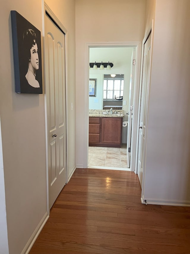 1082 Paddock Dr Unit 78, South Lyon, MI 48178 - hall with light wood-style floors, baseboards, and a sink
