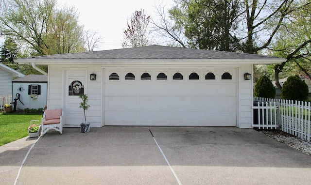 detached garage featuring fence