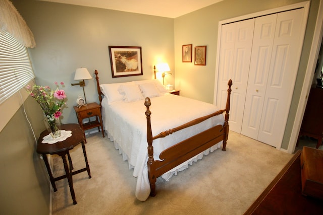 bedroom with a closet and light carpet