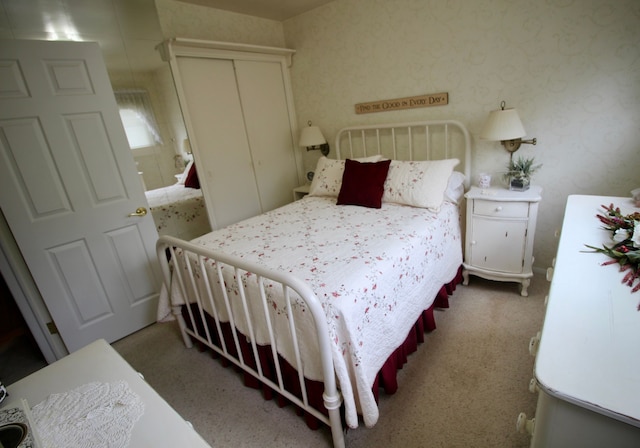 bedroom with carpet floors, a closet, and wallpapered walls