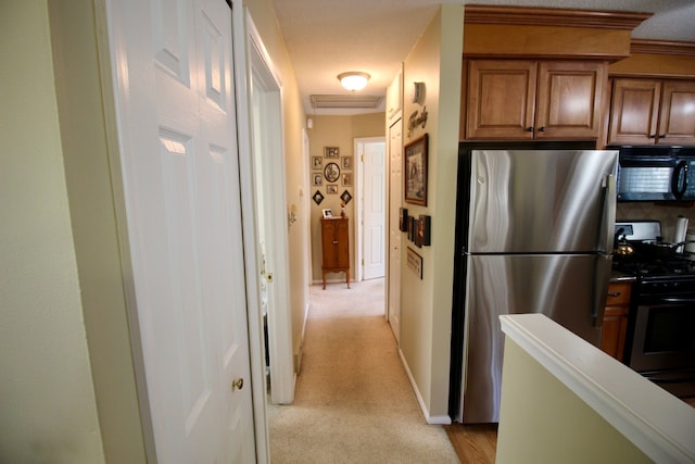 hallway with baseboards and light colored carpet