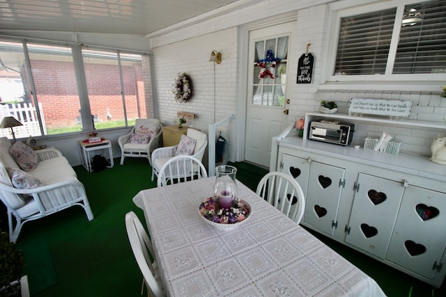 sunroom featuring outdoor dining area and a toaster