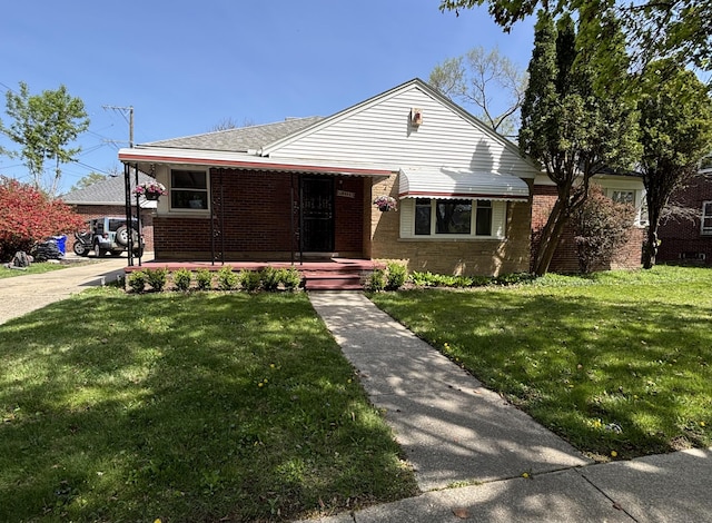 bungalow-style house with brick siding, roof with shingles, and a front yard