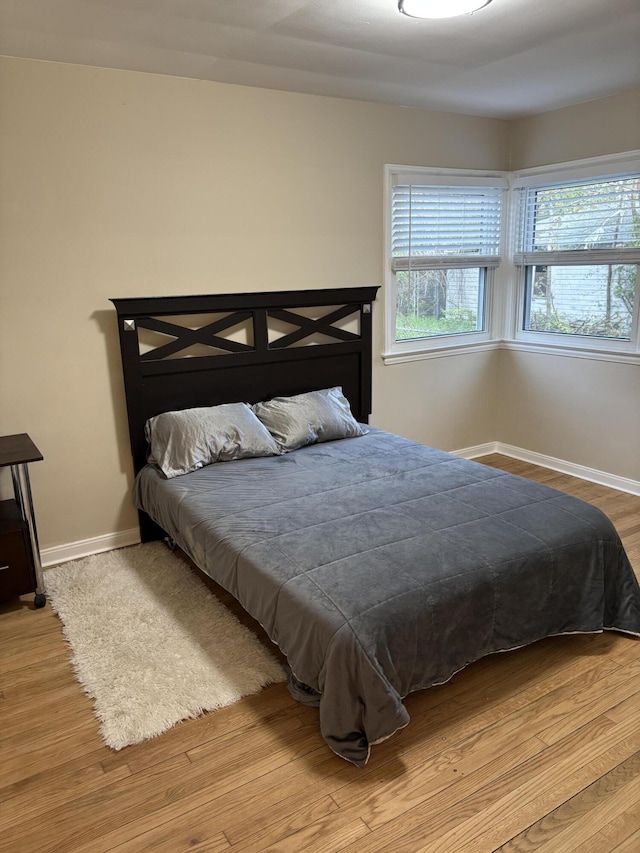 bedroom with baseboards and wood finished floors