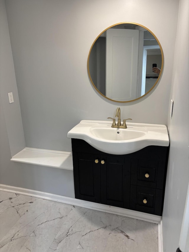 bathroom with baseboards, vanity, and marble finish floor