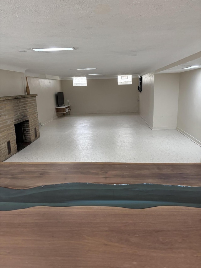 basement featuring a brick fireplace and a textured ceiling