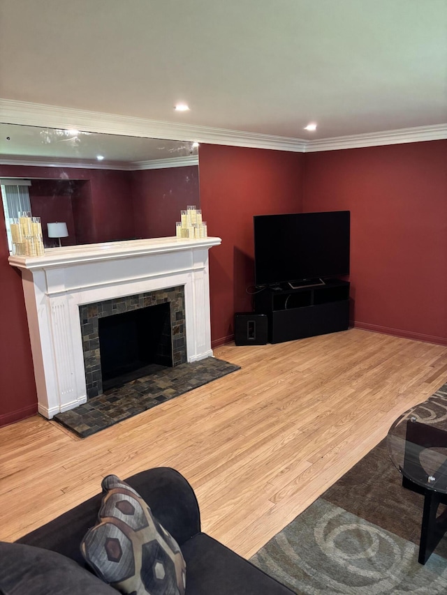 living room featuring crown molding, recessed lighting, wood finished floors, and a fireplace
