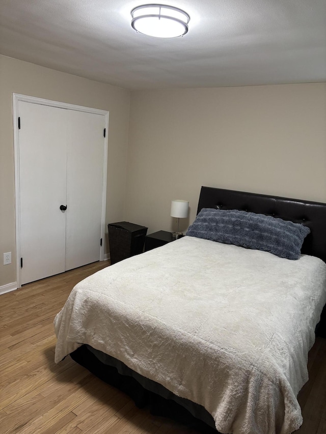 bedroom with baseboards and wood finished floors