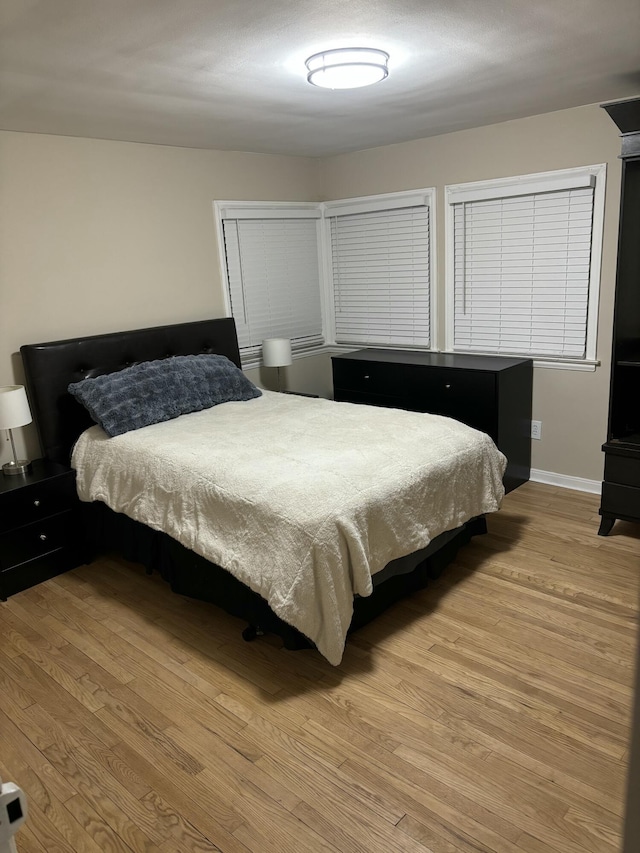 bedroom featuring baseboards and wood finished floors
