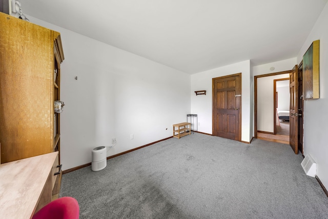 unfurnished bedroom featuring baseboards, carpet flooring, and visible vents