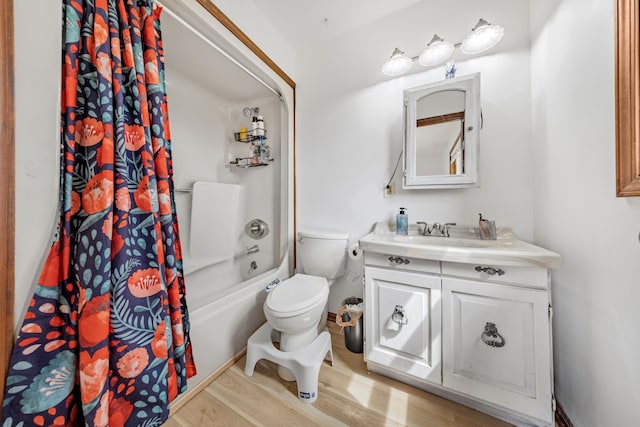 bathroom featuring toilet, shower / bath combination with curtain, wood finished floors, and vanity