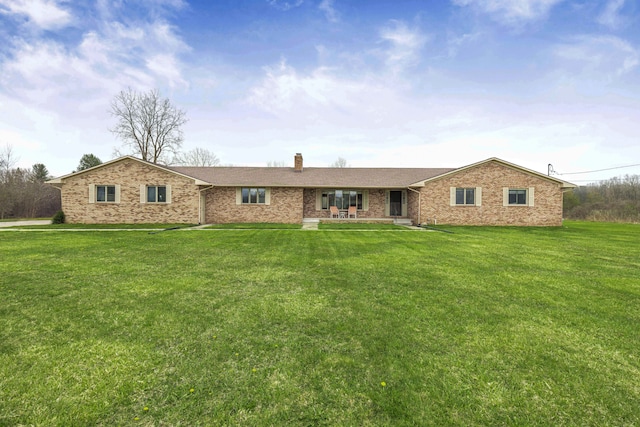 single story home with a patio, a chimney, a front lawn, and brick siding