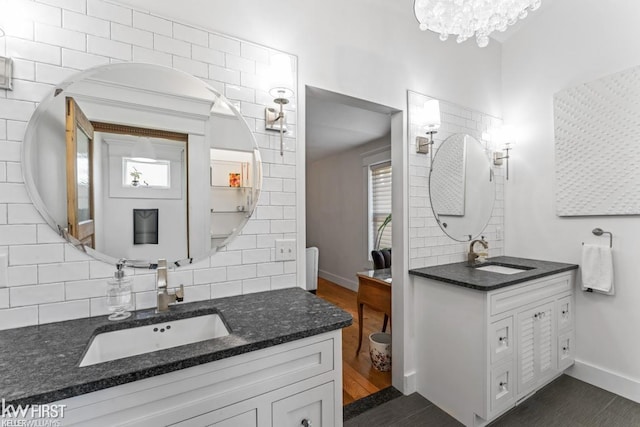 full bath featuring a sink, baseboards, backsplash, and wood finished floors