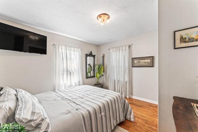 bedroom with baseboards and wood finished floors