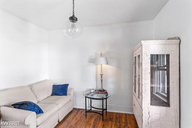 living area with baseboards and wood finished floors