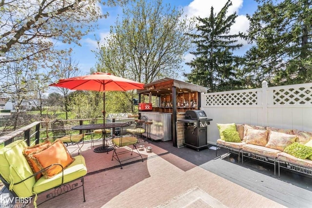 view of patio / terrace featuring an outdoor living space, fence, outdoor dry bar, and area for grilling