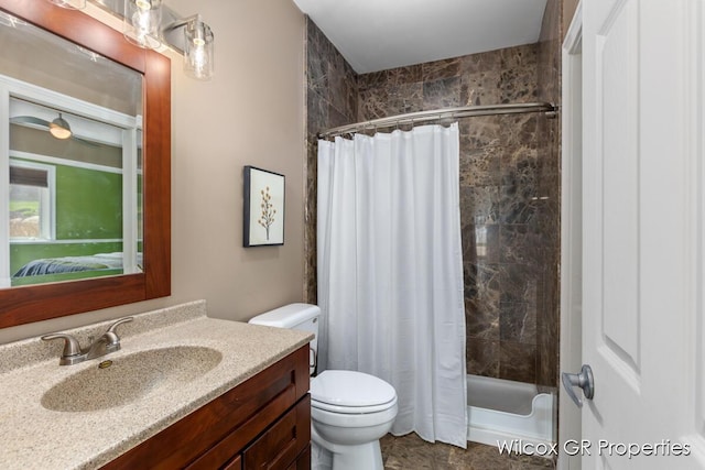 ensuite bathroom featuring vanity, shower / tub combo with curtain, connected bathroom, and toilet