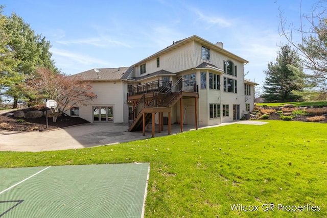 rear view of house with stairway, a patio, a wooden deck, and a lawn