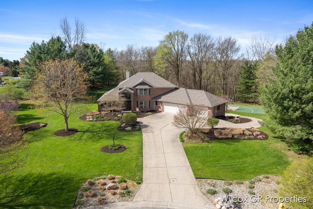 view of front facade with an attached garage, a front lawn, driveway, and a chimney