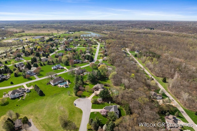 drone / aerial view featuring a water view and a view of trees