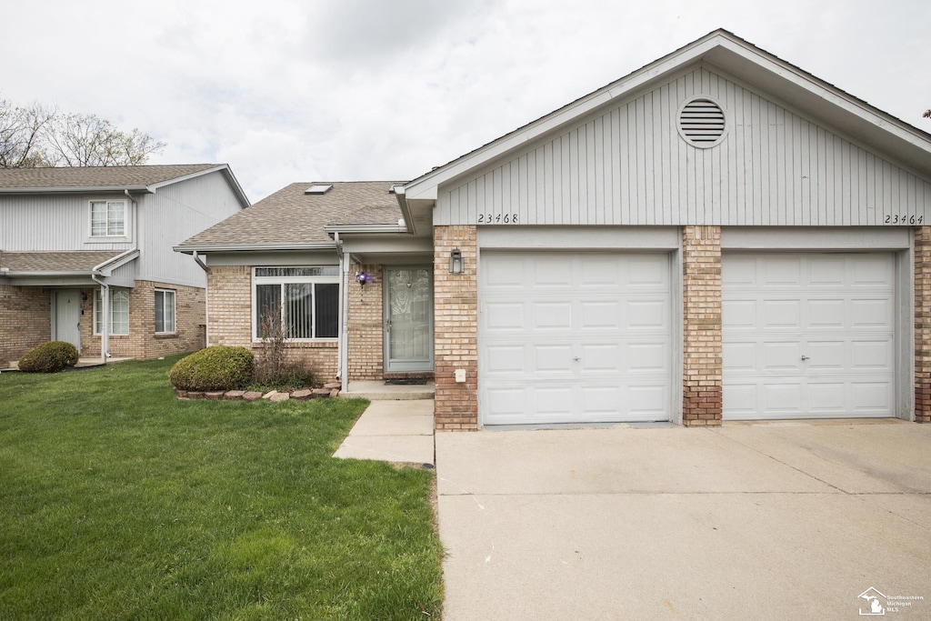 view of front of property featuring a shingled roof, a front lawn, brick siding, a garage, and driveway