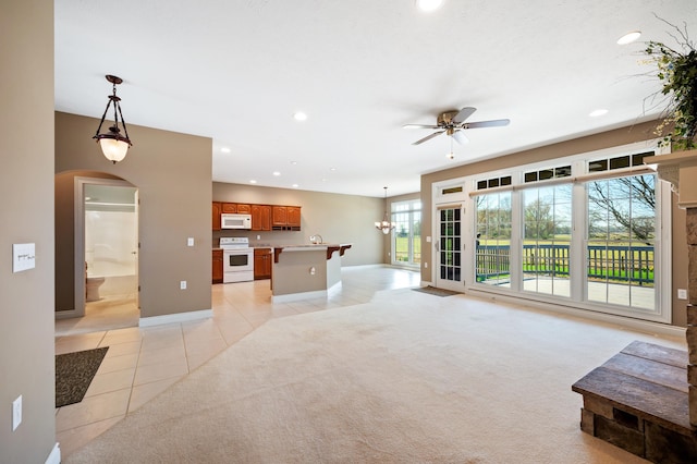 unfurnished living room with light tile patterned floors, baseboards, a ceiling fan, and recessed lighting