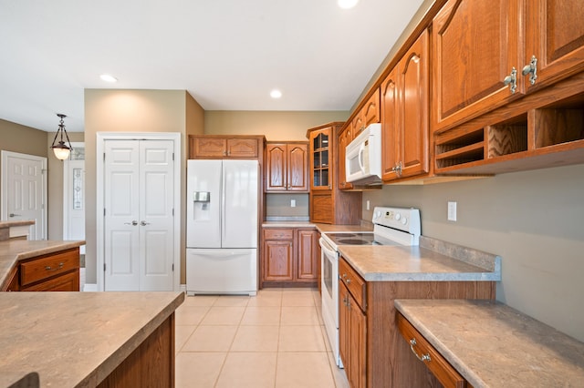 kitchen featuring white appliances, light countertops, brown cabinetry, light tile patterned floors, and glass insert cabinets