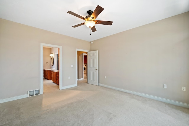 unfurnished bedroom with baseboards, visible vents, ensuite bath, and light colored carpet