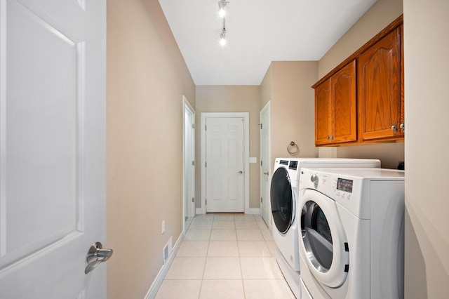 laundry area with visible vents, washing machine and dryer, cabinet space, baseboards, and light tile patterned flooring