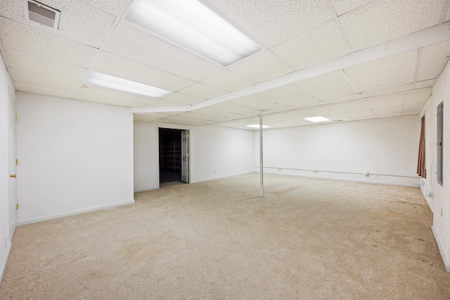 finished below grade area featuring visible vents, carpet flooring, and a drop ceiling