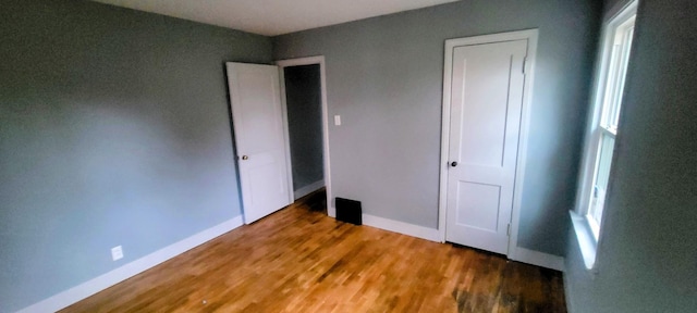 unfurnished bedroom featuring baseboards and wood finished floors