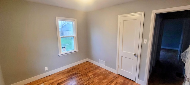 spare room featuring visible vents, light wood-style flooring, plenty of natural light, and baseboards