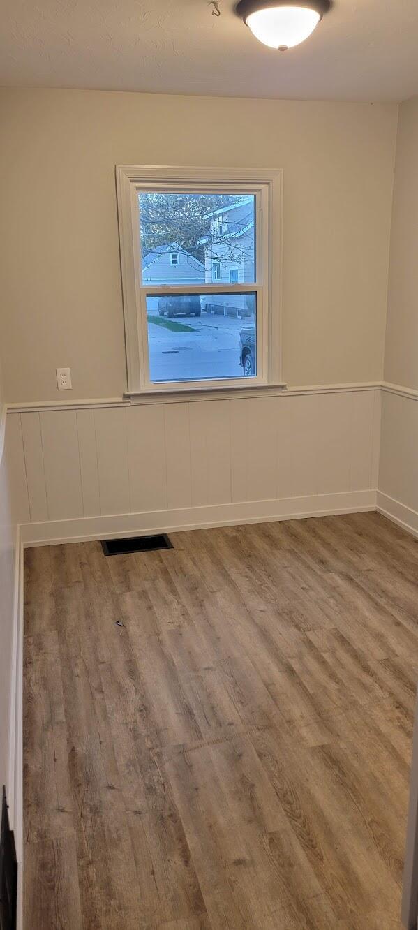 unfurnished room featuring visible vents and wood finished floors