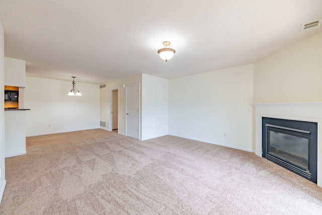 unfurnished living room with visible vents, carpet flooring, baseboards, and a glass covered fireplace