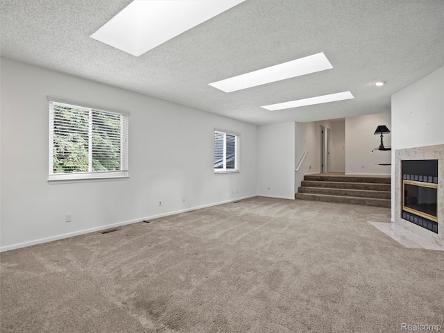 5620 Eastman Blvd, West Bloomfield, MI 48323 - unfurnished living room with a skylight, stairs, a tiled fireplace, a textured ceiling, and carpet flooring