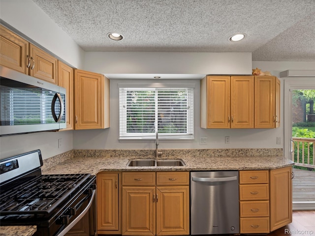 5620 Eastman Blvd, West Bloomfield, MI 48323 - kitchen with stainless steel appliances, a sink, a textured ceiling, light stone counters, and recessed lighting
