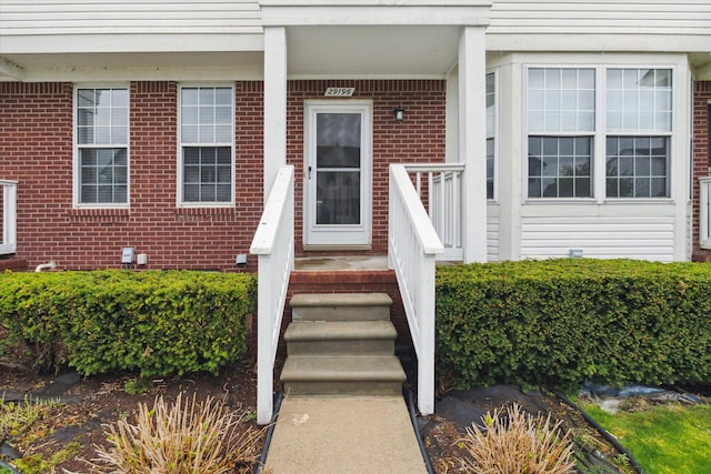 doorway to property featuring brick siding