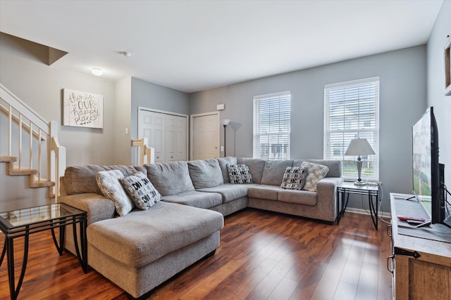 living room featuring stairs and dark wood-style floors