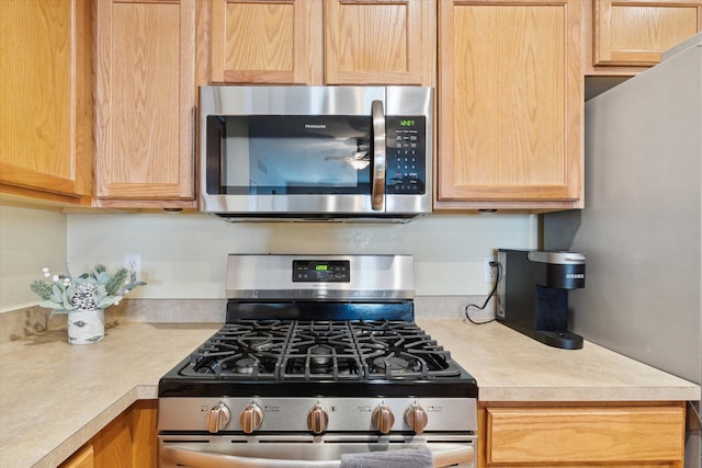 kitchen featuring light countertops, light brown cabinetry, and stainless steel appliances