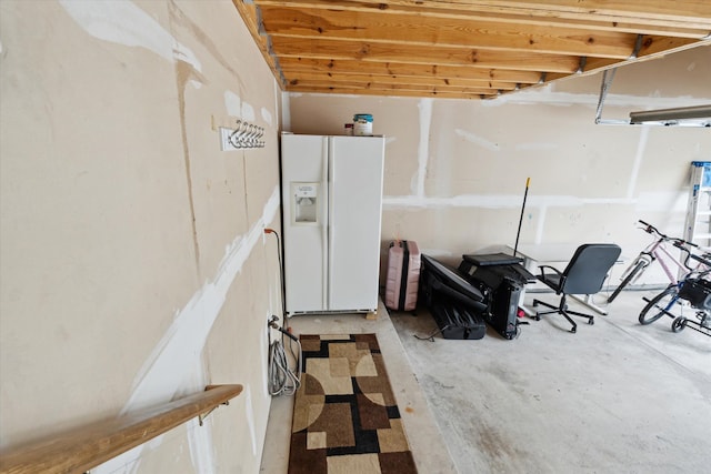basement featuring white fridge with ice dispenser