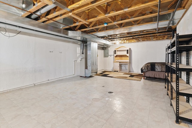 finished basement featuring heating unit and electric panel