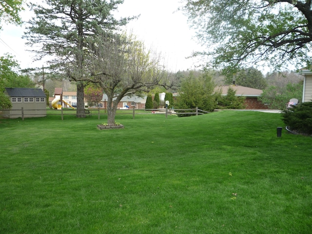 view of yard with fence and a playground