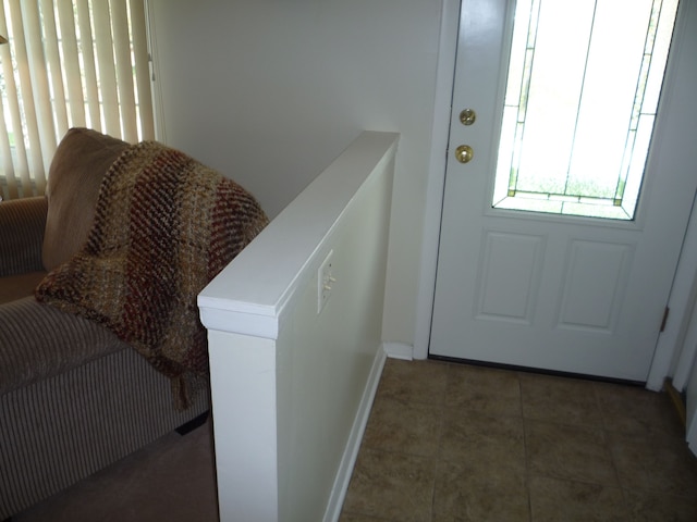doorway to outside featuring baseboards and tile patterned floors