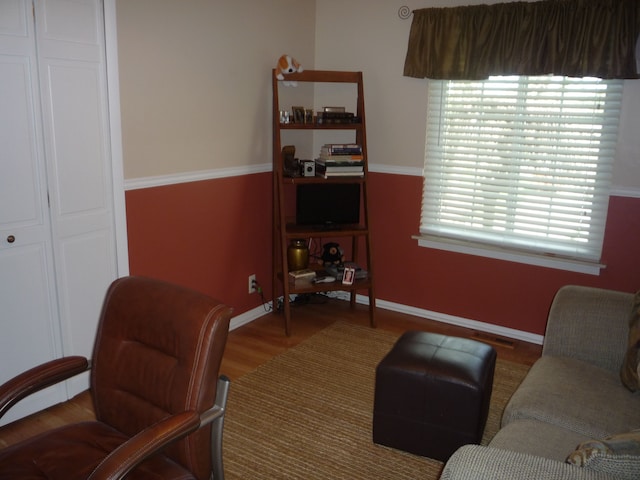 living area featuring a healthy amount of sunlight, wood finished floors, and visible vents