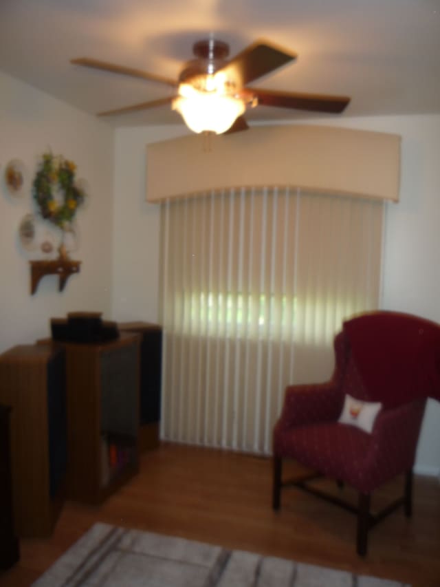 sitting room with ceiling fan and wood finished floors
