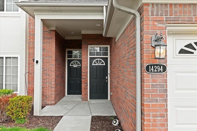 view of exterior entry featuring brick siding