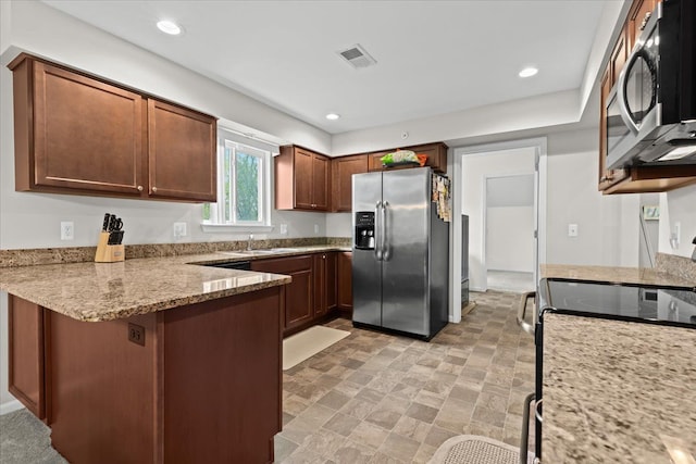 kitchen featuring visible vents, light stone countertops, a sink, a peninsula, and stainless steel appliances