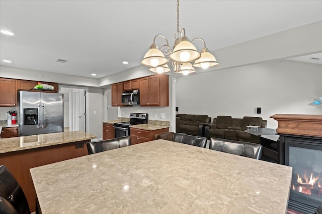 kitchen featuring brown cabinetry, visible vents, appliances with stainless steel finishes, a notable chandelier, and recessed lighting