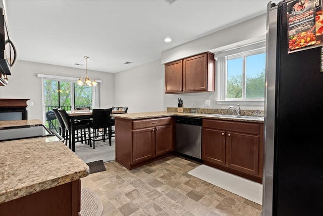 kitchen featuring a sink, light countertops, a peninsula, a notable chandelier, and stainless steel appliances